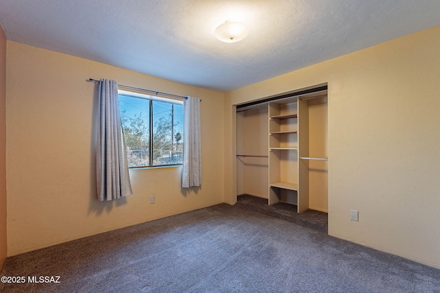 unfurnished bedroom featuring a textured ceiling, a closet, and carpet