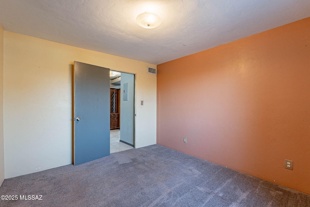 unfurnished room featuring carpet floors, visible vents, and a textured ceiling