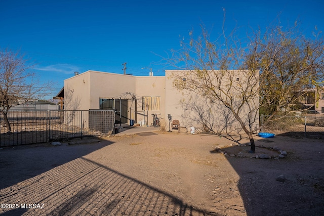 back of house with fence and stucco siding