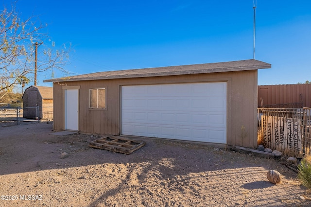 detached garage featuring fence