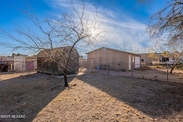 back of property with a storage shed, a fenced backyard, and an outbuilding