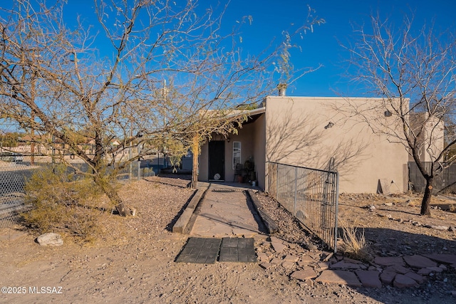 view of side of home with fence and stucco siding