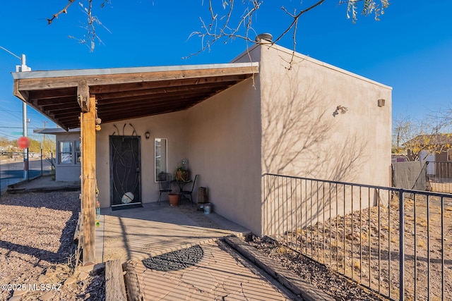 view of side of property with fence and stucco siding