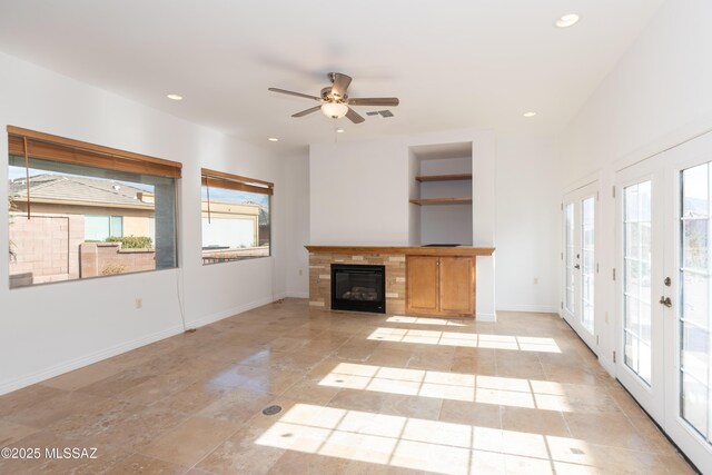 unfurnished living room featuring ceiling fan, french doors, built in features, and a wealth of natural light