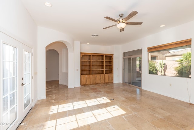 unfurnished room with ceiling fan, french doors, and plenty of natural light