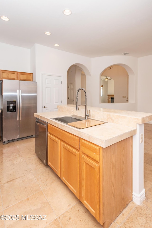 kitchen with sink, stainless steel appliances, a kitchen island with sink, and ceiling fan