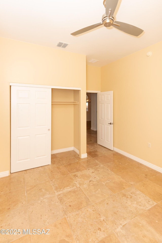 unfurnished bedroom with ceiling fan and a closet