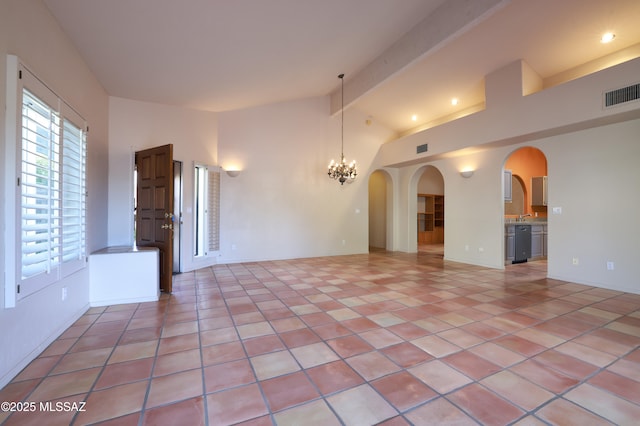 empty room featuring a notable chandelier, lofted ceiling with beams, and light tile patterned floors