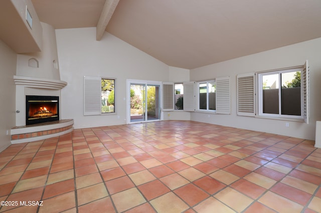 unfurnished living room with beam ceiling, high vaulted ceiling, and light tile patterned flooring