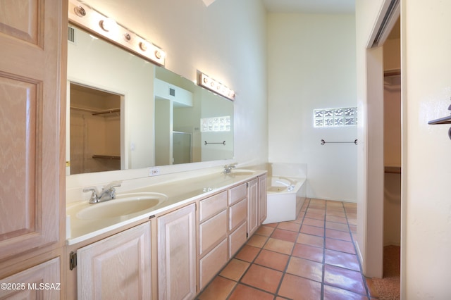 bathroom featuring tile patterned flooring, independent shower and bath, and vanity