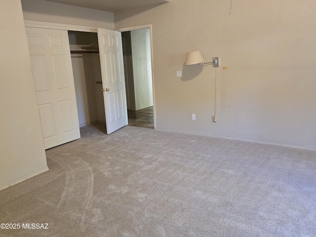 unfurnished bedroom featuring light carpet and a closet