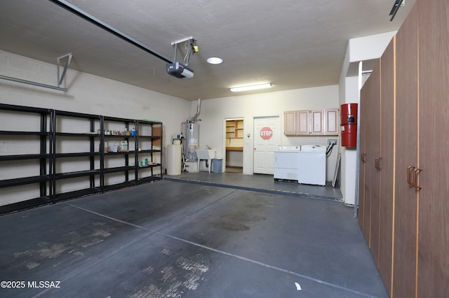 garage featuring sink, gas water heater, a garage door opener, and separate washer and dryer