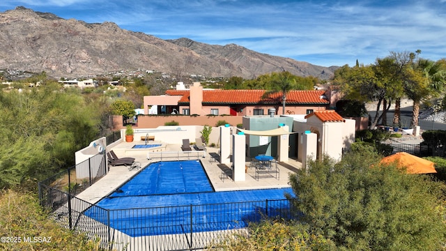 view of swimming pool featuring a patio and a mountain view