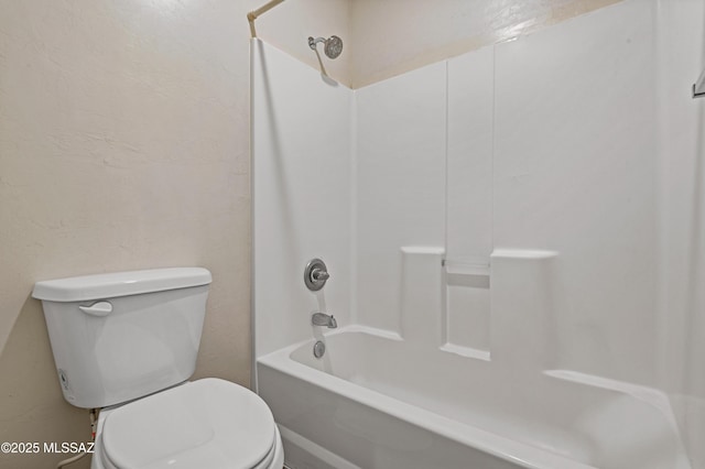 bathroom with washtub / shower combination and toilet