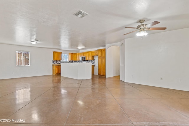 unfurnished living room featuring ceiling fan