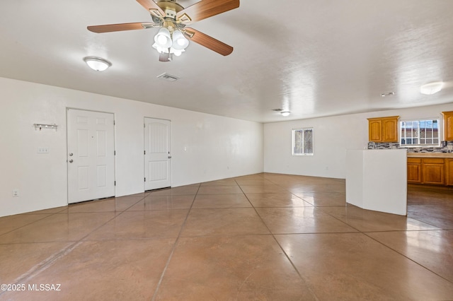 unfurnished room with a wealth of natural light and ceiling fan