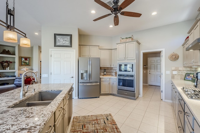 kitchen with sink, hanging light fixtures, light tile patterned floors, tasteful backsplash, and stainless steel appliances