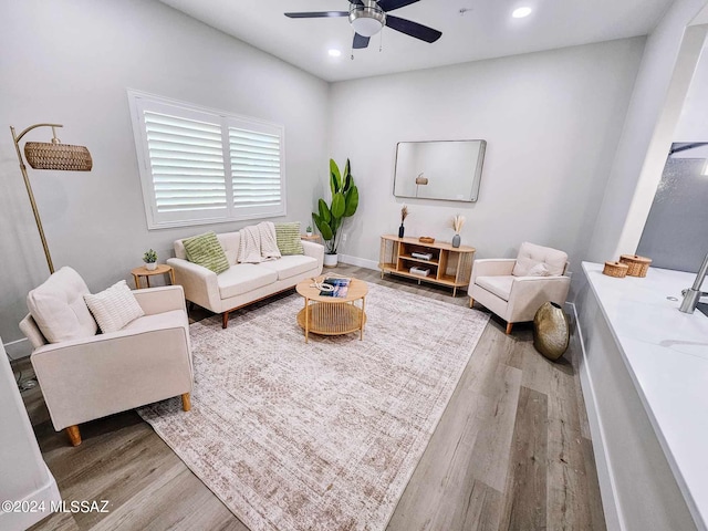 living room with light hardwood / wood-style flooring and ceiling fan