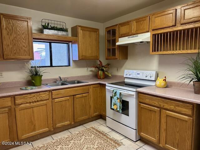 kitchen featuring light tile patterned floors, sink, and white electric stove