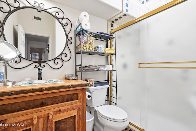 bathroom with toilet, an enclosed shower, and vanity