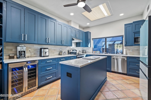 kitchen featuring a kitchen island, appliances with stainless steel finishes, wine cooler, and blue cabinets