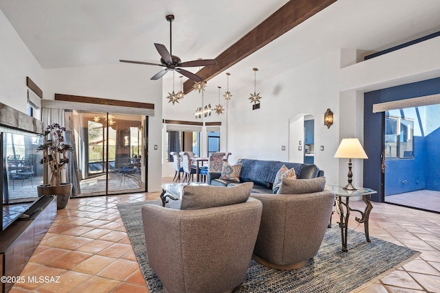 tiled living room featuring ceiling fan with notable chandelier, high vaulted ceiling, a wealth of natural light, and beamed ceiling