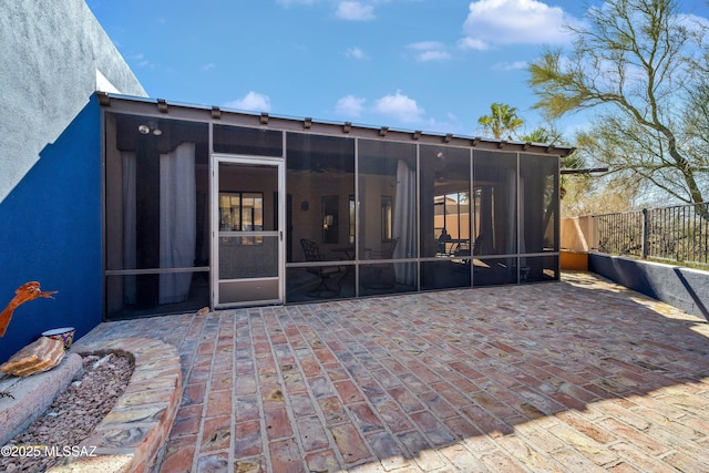 rear view of property featuring a patio and a sunroom