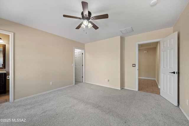 unfurnished bedroom with ceiling fan, light colored carpet, and connected bathroom