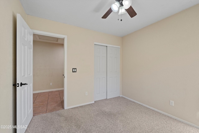 unfurnished bedroom featuring ceiling fan, light colored carpet, and a closet