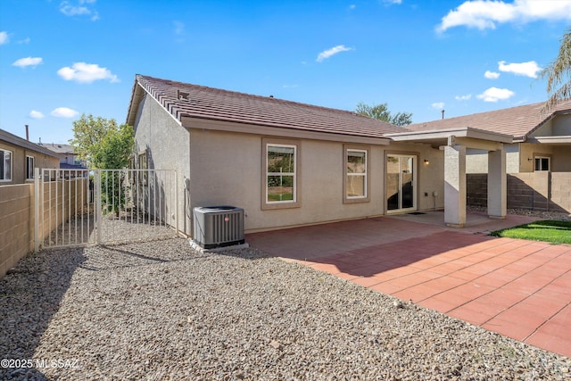 rear view of house with central AC unit and a patio