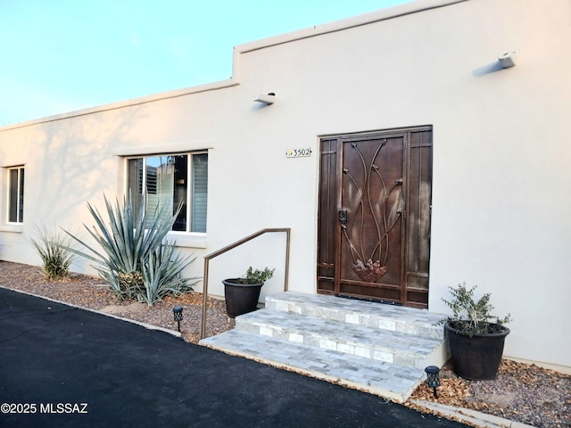 entrance to property with stucco siding