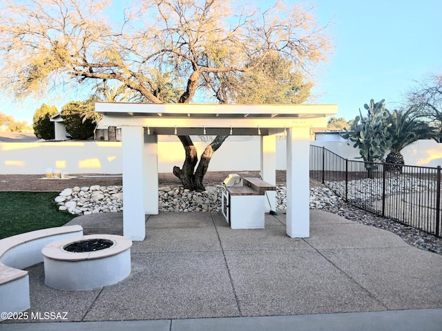 view of patio / terrace with an outdoor fire pit and fence