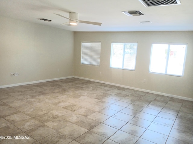 spare room with visible vents, ceiling fan, and baseboards