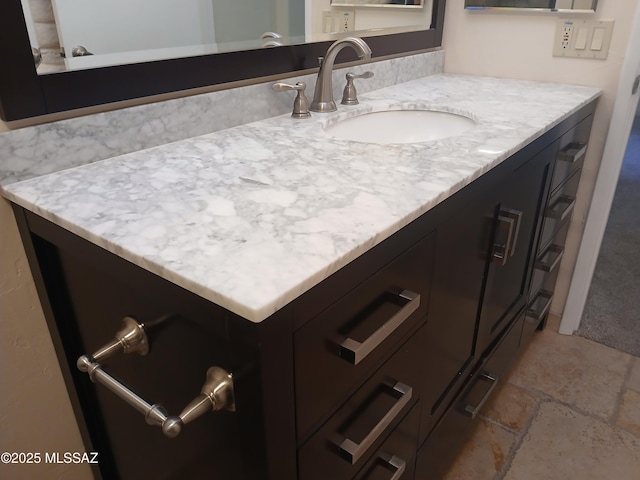 bathroom with stone tile floors and vanity