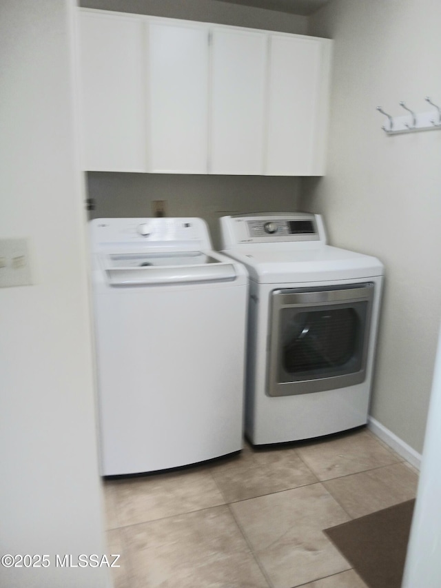 laundry room with cabinet space, light tile patterned flooring, and independent washer and dryer