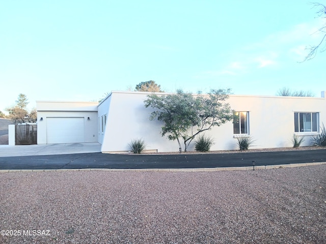 view of front of property with a garage, driveway, and stucco siding