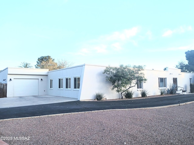 view of front of home featuring driveway, a garage, and stucco siding