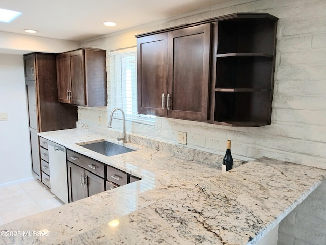 kitchen featuring a sink, dark brown cabinets, light stone countertops, dishwasher, and a peninsula