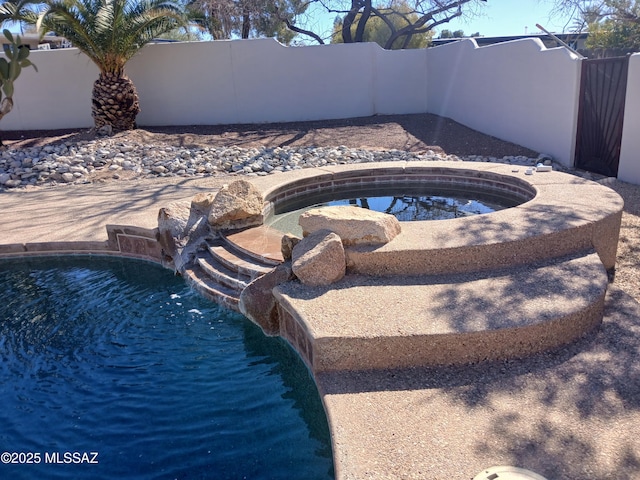 view of pool featuring fence, a fenced in pool, and an in ground hot tub