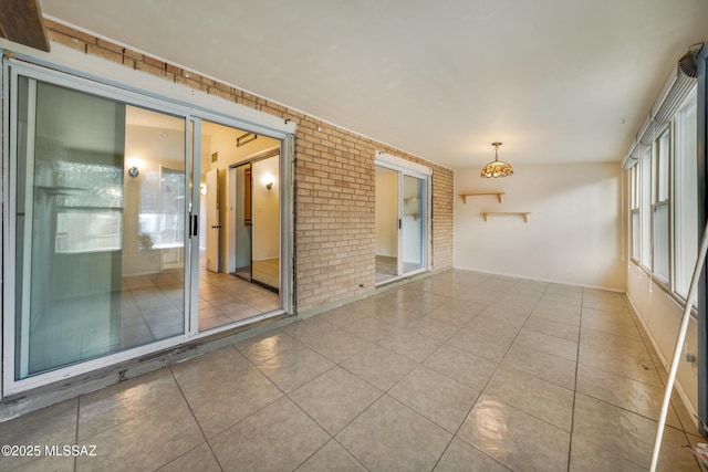 tiled empty room featuring brick wall