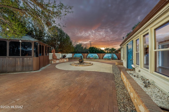 yard at dusk featuring a fenced backyard and a patio