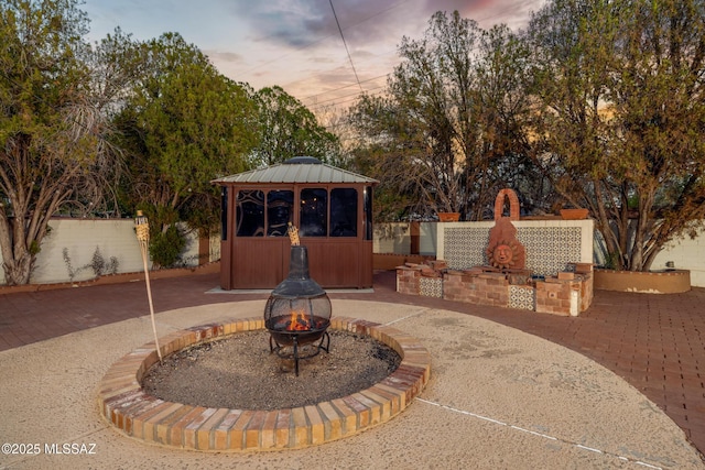 view of patio with an outdoor fire pit, a fenced backyard, and a gazebo