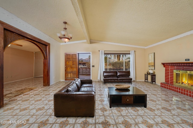 living area with arched walkways, lofted ceiling with beams, a textured ceiling, a fireplace, and a chandelier