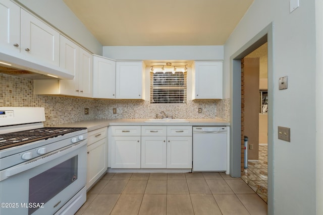 kitchen with light countertops, backsplash, a sink, white appliances, and under cabinet range hood