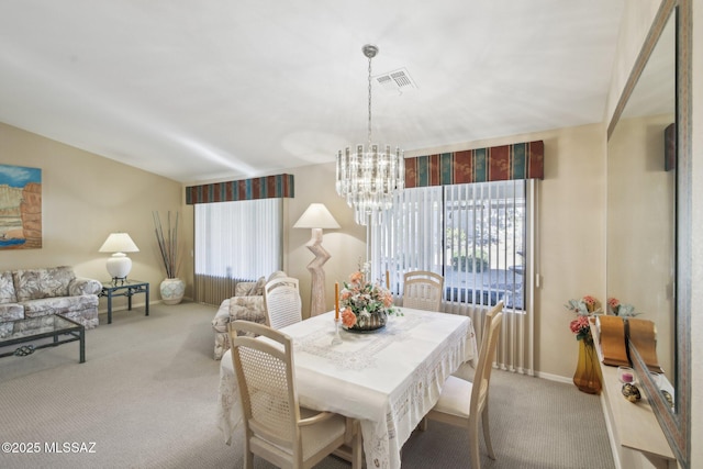 dining space with light carpet and an inviting chandelier