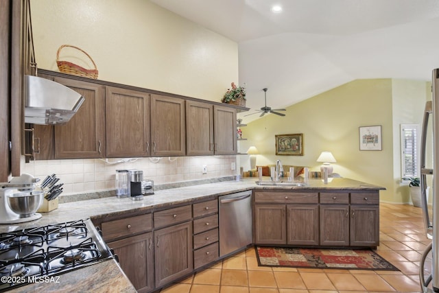 kitchen with wall chimney range hood, decorative backsplash, stainless steel dishwasher, and sink