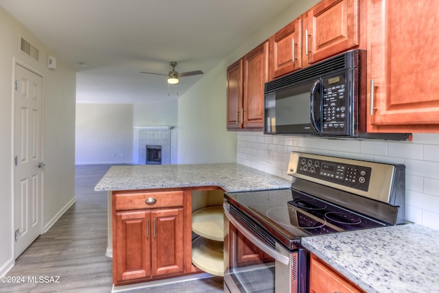 kitchen featuring ceiling fan, tasteful backsplash, light hardwood / wood-style flooring, kitchen peninsula, and stainless steel range with electric stovetop