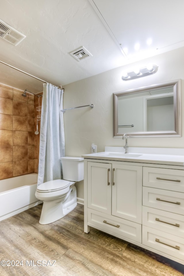 full bathroom featuring wood-type flooring, shower / bath combination with curtain, vanity, and toilet