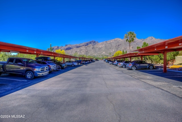 view of vehicle parking with a carport and a mountain view