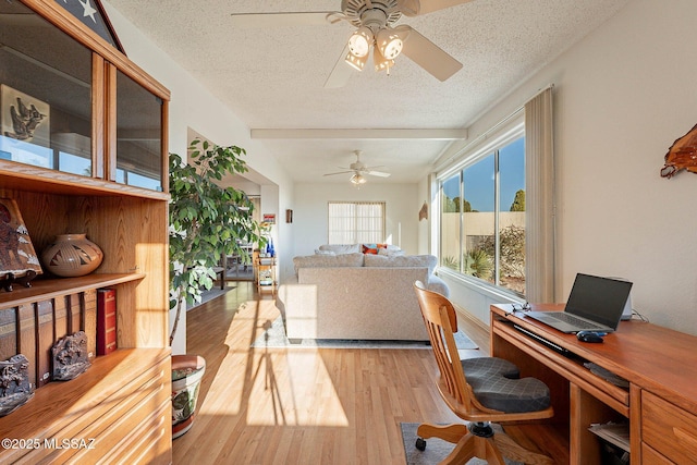 office with ceiling fan, light hardwood / wood-style floors, a textured ceiling, and lofted ceiling with beams